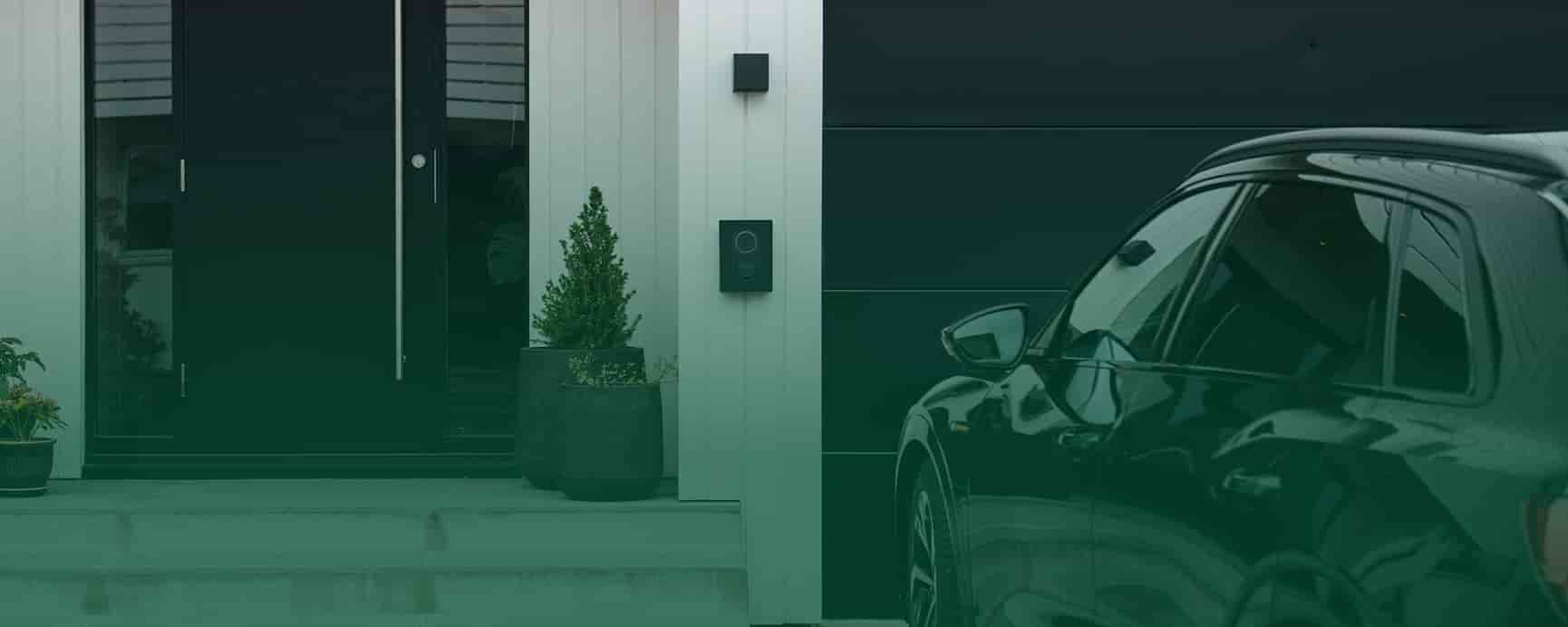 elbil holder i indkørsel foran garage