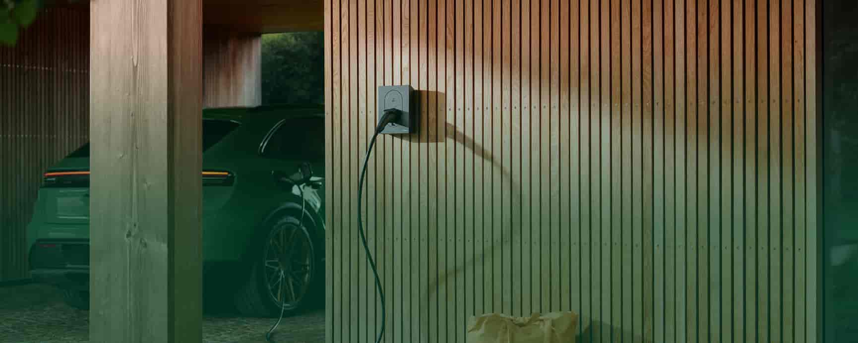 kvinde står med mobil mens elbil oplader