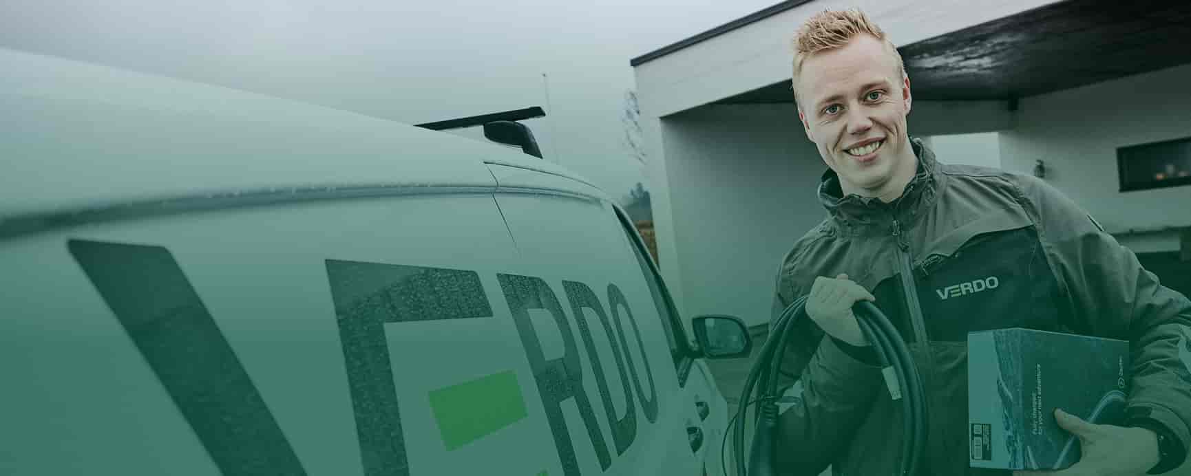 Verdo medarbejder ved siden af Verdo bil med ladeboks og ladekabel